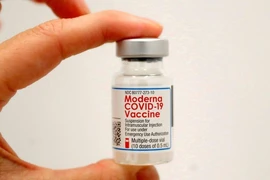 Một nhân viên y tế cầm một lọ vaccine ngừa COVID-19 của Moderna.