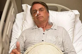 Tổng thống Brazil Jair Bolsonaro giơ ngón tay cái trong khi đang nằm viện do chứng tắc nghẽn đường ruột ở Sao Paulo, Brazil ngày 3-1. 