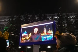Người dân Nga đứng xem đoạn video Tổng thống Vladimir Putin đưa ra thông điệp năm mới ở Kemerovo vào ngày 31-12-2021.