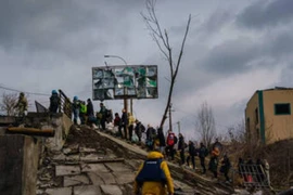 Người dân Ukraine băng qua sông Irpin gần thủ đô Kiev, ngày 4-3.