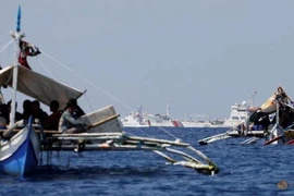Tàu tuần duyên Trung Quốc đi ngang qua các tàu đánh cá của Philippines tại bãi cạn Scarborough đang tranh chấp trên Biển Đông.