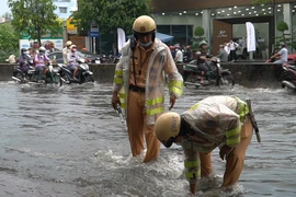 Video: CSGT lội nước giúp dân khơi miệng cống chống ngập