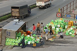 Xe tải chở nước ngọt lật nhào, nhiều người xông vào 'hôi của'