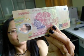 Có thể dễ dàng nhận biết tiền giả polymer bằng tay và mắt thường. (Ảnh minh họa: KT)