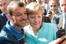 Bà Angela Merkel chụp ảnh với một người tị nạn ở thủ đô Berlin (Đức) ngày 9-9-2015. Ảnh: AP