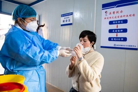 Người dân tỉnh Hồ Nam (TQ) dùng một liều vaccine COVID-19 dạng hít tại một trung tâm dịch vụ y tế cộng đồng tỉnh Hồ Nam (TQ) ngày 22-12-2022. Ảnh: TÂN HOA XÃ