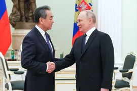 Tổng thống Nga Vladimir Putin (phải) bắt tay với Chủ nhiệm Văn phòng Ủy ban Công tác đối ngoại Trung ương đảng Cộng sản TQ Vương Nghị tại thủ đô Moscow (Nga) ngày 22-2. Ảnh: RT