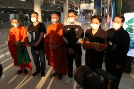 Huấn luyện viên Kiatisuk Senamuang (giữa), các sư thầy, gia đình Duangpetch Promthep cùng di cốt của cậu tại sân bay quốc tế Suvarnabhumi, tỉnh Samut Prakan (Thái Lan). Ảnh: FACEBOOK