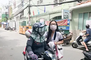 Phụ huynh TP.HCM đưa con đi thi che chắn kín mít để chống nóng. Ảnh: Phan Yên 