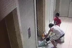 Xe đẩy kẹt thang máy, bé trai bị kéo lên không trung