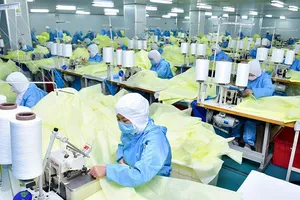 Công nhân mang khẩu trang tăng ca ở Hồ Bắc (Trung Quốc). Ảnh: CHINA DAILY