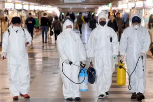 Nhân viên y tế đang khử trùng tại một khu chợ. Ảnh: REUTERS