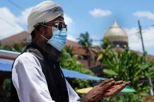 Một người đàn ông đeo khẩu trang, khử trùng tay sau khi bước ra từ Nhà thờ Hồi giáo Sri Petaling ở Kuala Lumpur (Malaysia). Ảnh: AFP