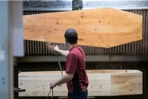 Một công nhân đang phủ vecni cho quan tài. Ảnh: AFP