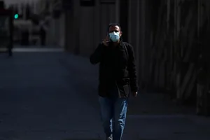 Nam thanh niên đeo khẩu trang đi trên phố Regent không một bóng người ở London, Anh, ngày 13-4. Ảnh: REUTERS