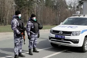 Các nhân viên thực thi pháp luật đeo khẩu trang đứng ở một trạm kiểm soát ở Moscow được thiết lập sau khi chính quyền thủ đô siết chặt các biện pháp, nhằm ngăn chặn sự lây lan của bệnh COVID-19. Ảnh: REUTERS