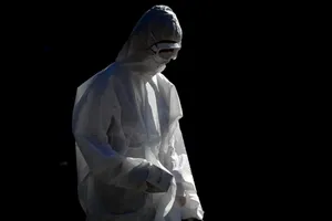 Một người dân mặc trang phục bảo hộ đi bộ gần gần Công viên St James, ở thành phố Newcastle, Anh. Ảnh: REUTERS