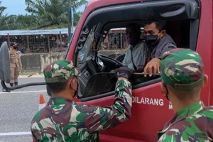 Binh sĩ kiểm tra việc chấp hành hạn chế đi lại trên một đường cao tốc ở TP Pekanbaru (Indonesia) ngày 22-4. Ảnh: GETTY IMAGES