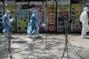 Nhân viên y tế đi ngang qua một khu vực đỏ (khu vực có nguy cơ lây nhiễm cao) được rào kẽm gai ở thành phố Petaling Jaya, Malaysia. Ảnh: REUTERS