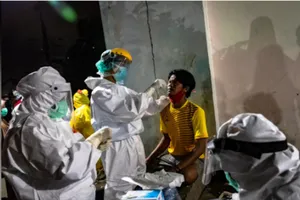 Nhân viên y tế lấy mẫu bệnh phẩm từ một người bán hàng ở chợ truyền thống ở TP Semarang, đảo Java, Indonesia. Ảnh: REUTERS