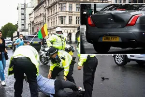 Các sĩ quan cảnh sát bắt giữ người biểu tình gần Tòa nhà Quốc hội sau khi ông này lao vào đoàn xe thủ tướng. Ảnh nhỏ cho thấy chiếc xe chở thủ tướng bị móp phần đuôi sau vụ va chạm. Ảnh: REUTERS/RT