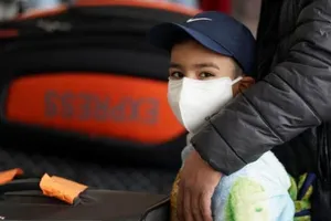 Một cậu bé mang khẩu trang khi đang đứng làm thủ tục ở sân bay quốc tế Dulles, thủ đô Washington, D.C, Mỹ. Ảnh: REUTERS/ALARABIYA