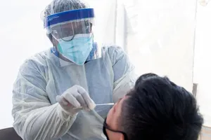 Nhân viên y tế lấy mẫu xét nghiệm COVID-19 cho một học sinh tại TP Los Angeles, bang California (Mỹ) ngày 24-7. Ảnh: VALERIE MACON/AFP/GETTY/CNN