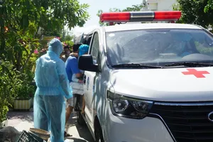 Xe cứu thương đưa con rể và cháu ngoại của bệnh nhân TVD đi cách ly. Ảnh: TẤN VIỆT