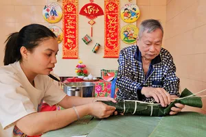 Cụ ông U90 tỉ mẩn truyền nghề gói bánh tét cho con cháu ngày Tết