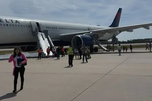 Các hành khách trên chiếc Airbus A330 mang số hiệu 1213 đã được sơ tán sau vụ cháy động cơ máy bay hôm 21-4 ở TP Orlando (bang Florida, Mỹ). Ảnh: SPECTRUM NEWS 13