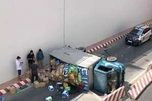 Xe tải lật, người dân giúp tài xế gom hàng hóa