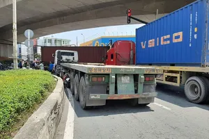 Container ôm cua ép hai cô gái đi xe máy văng vào lề ở quận 7