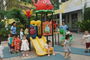 Cô và bé Trường Mầm non Mặt Trời Nhỏ đang vui chơi ngoài trời trong giờ giải lao. Ảnh: NGUYỄN QUYÊN