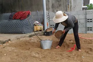 Người dân đưa cát lên nóc chằng chống nhà