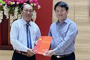 Ông Đặng Ngọc Huy, Phó Bí thư Tỉnh ủy Quảng Ngãi (phải), trao quyết định cho ông Nguyễn Quốc Việt. Ảnh: H.HÀ