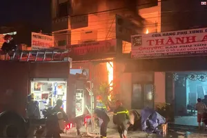 Cảnh sát dập lửa, cứu người trong đám cháy ở Quảng Ngãi. Ảnh: H.HÀ