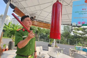 Thiếu tá Lý Hoàng Hướng hướng dẫn lực lượng bảo vệ dân phố cách đánh chuông và nói về công dụng của chuông. Ảnh: TS