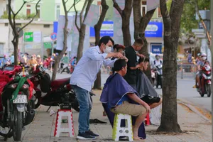 Người dân đến cắt tóc tại khu vực công viên Bình Phú (đường Nguyễn Văn Luông, quận 6, TP.HCM). Ảnh: MINH THUẬN