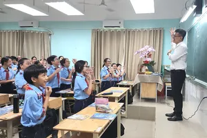 Thầy Phạm Kiên Thành, giáo viên Trường THCS Lý Tự Trọng, quận Gò Vấp, cùng học sinh khởi động đầu tiết học. Ảnh: NGUYỄN QUYÊN