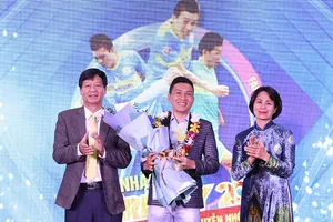 Nguyễn Nhớ chân chất nhận danh hiệu Fair Play 2020 trong sự chúc mừng của ông Lê Khắc Hiệp, Phó Chủ tịch tập đoàn Vingroup (trái) và bà Lê Thị Hoàng Yến, Phó Tổng cục trưởng Tổng cục TDTT.