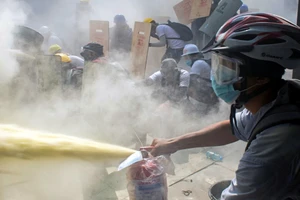 Người biểu tình Myanmar dùng khiên tự chế và bình cứu hỏa để cản lại hơi cay từ phía cảnh sát ở TP Yangon ngày 3-3.