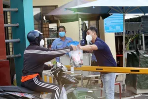 Người thân tiếp tế đồ đạc cho nhân viên BV Bệnh nhiệt đới TP.HCM khi bệnh viện này tạm phong tỏa vì ca nhiễm COVID-19.