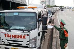 Xe cộ xếp hàng dài chờ xuất trình giấy thông hành khi qua chốt kiểm soát dịch COVID-19 tại chân cầu Vĩnh Bình (phường Hiệp Bình Phước, TP Thủ Đức), chiều 9-7. 