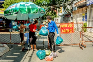 Cán bộ cơ sở hỗ trợ chuyển nhu yếu phẩm cho người dân ở những khu vực cách ly, phong tỏa.