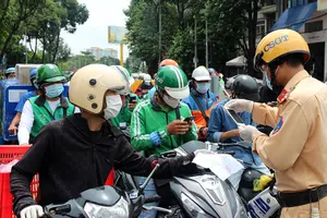 Lực lượng chức năng kiểm soát người dân khai báo “di biến động dân cư” khi qua chốt trên đường Đinh Bộ Lĩnh (quận Bình Thạnh, TP.HCM), sáng 15-8.