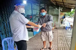 Cán bộ UBND phường Tân Tạo (quận Bình Tân, TP.HCM) trao túi thuốc cho F0 điều trị tại nhà.