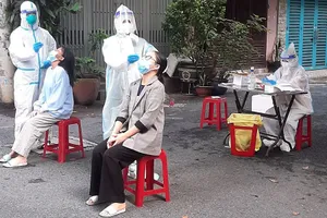  Nhân viên y tế của Trạm y tế phường 4, quận Tân Bình lấy mẫu xét nghiệm cho F0 cách ly tại nhà.