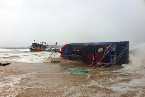 Một tàu cá bị sóng đánh bật lên bờ, hư hỏng tại cửa biển Tuy An, Phú Yên.
