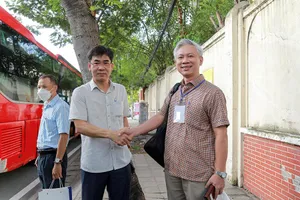 Ông Lê Trường Sơn (trái) động viên, dặn dò cán bộ, giảng viên trước giờ khởi hành đi Bình Thuận làm công tác kiểm tra thi.