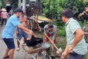 Người dân đang vệ sinh khu vực xung quanh nơi mình sinh sống để phòng chống dịch sốt xuất huyết.
